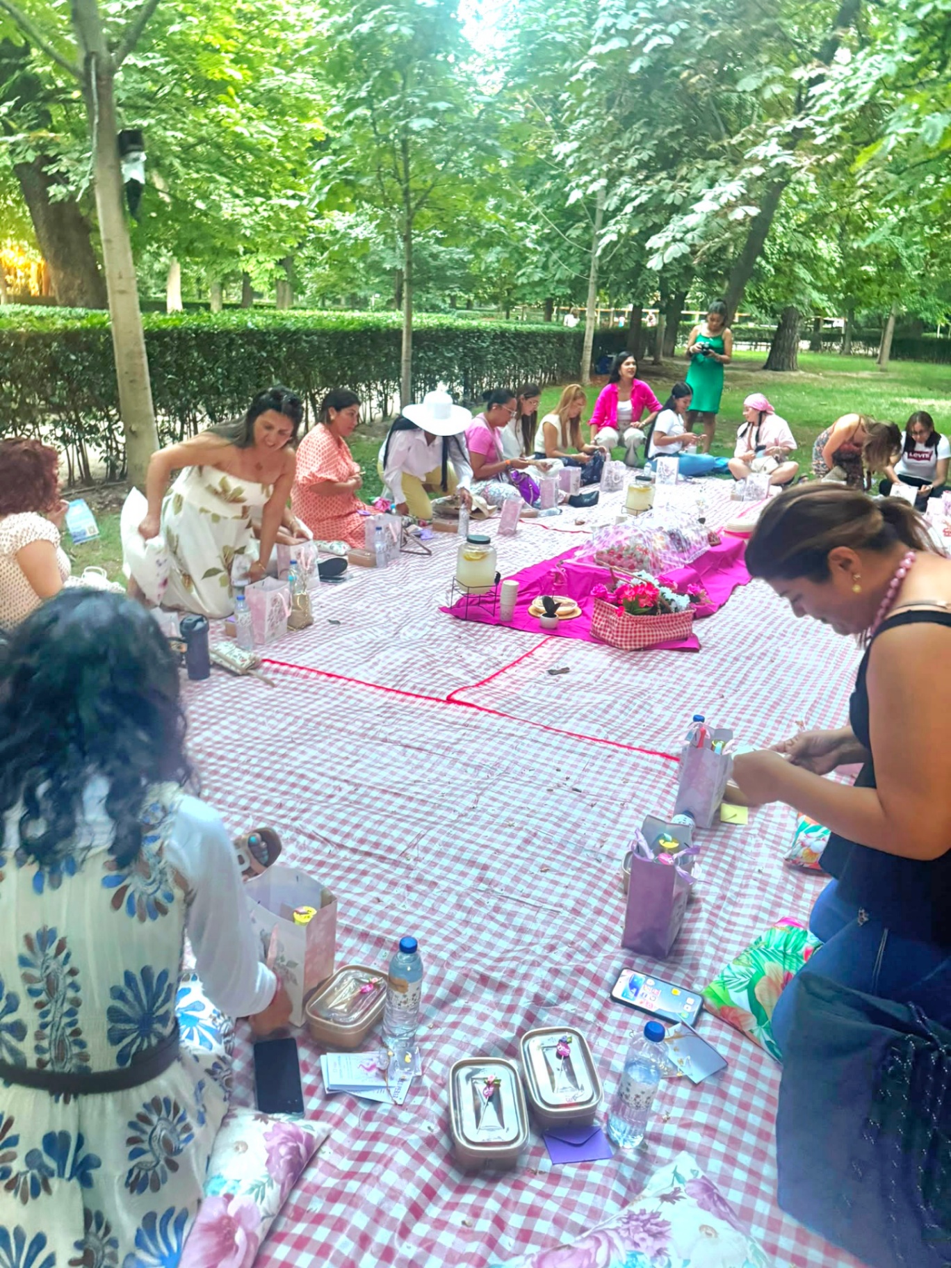 Mujeres abriendo sus bolsas de regalo sobre los manteles del picnic