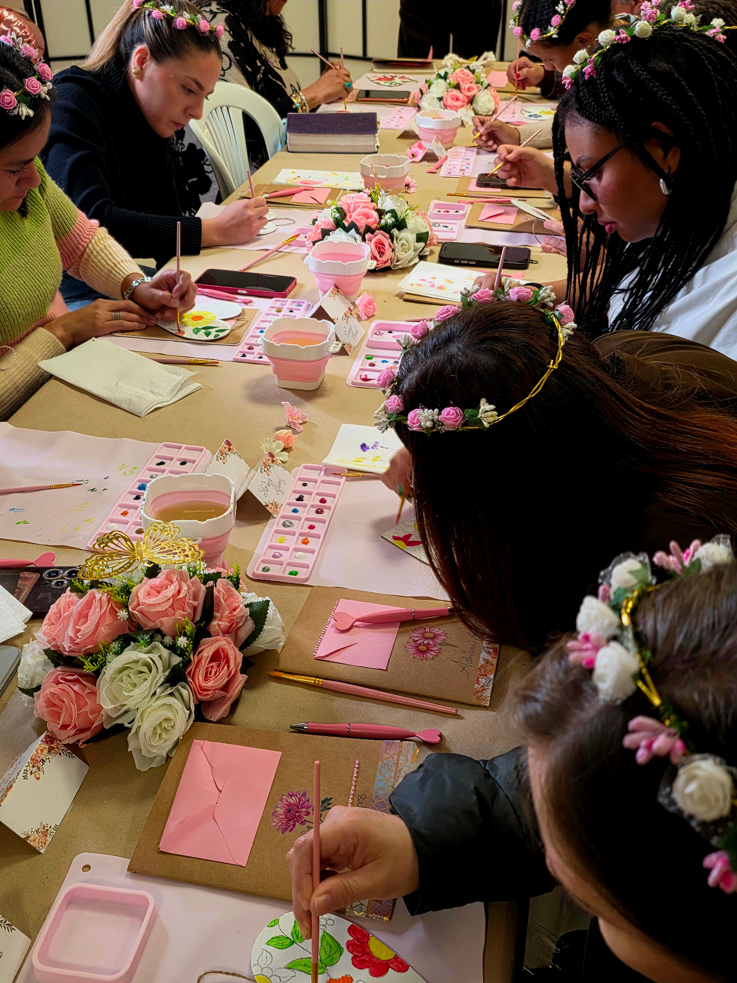 Mujeres con coronas de flores pintando en acuarela