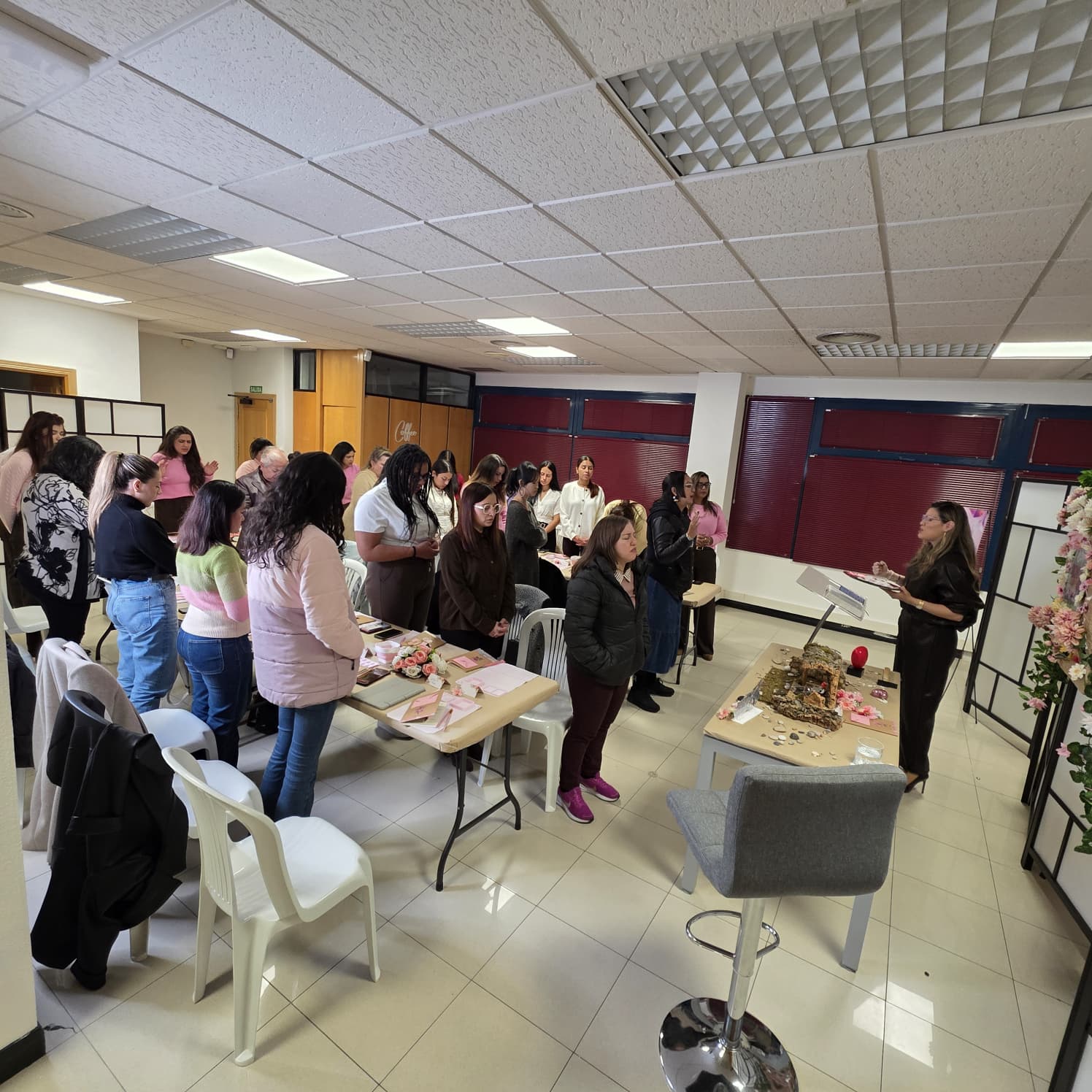 Grupo de mujeres en pie durante un momento de oración
